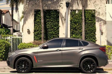 Miami, Florida, ABD - 12 Nisan 2025: gri renkli cip arabası, yan görüş. BMW X6 2016 çapraz coupe SUV arabası. Çapraz SUV aracı BMW X6. BMW X6 otomobili dışarıda park halinde..