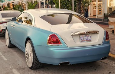 Miami, Florida, ABD - 08 Nisan 2025 Rolls Royce Wraith lüks Grand Tourer arabası. Büyük turnuva arabası Rolls Royce Wraith. Araba Rolls Royce Wraith dışarı park etmiş. Beyaz mavi araba, köşe manzaralı..