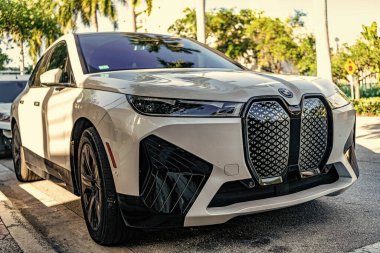 Miami, Florida, ABD - 05 Nisan 2025: Elektrikli çapraz araba BMW IX xDrive50. BMW IX elektrikli SUV dışarıda park halinde. Beyaz araba, köşe manzaralı. 2025 BMW IX xDrive50 lüks elektrikli arazi aracı.