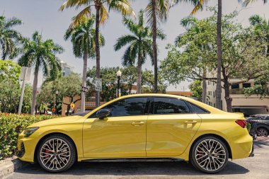 Miami, Florida, ABD - 07 Nisan 2025: lüks araba Audi S3. Araba Audi S3 dışarıda park edilmiş. Sarı hatchback araba, yan görüş. 2024 Audi S3 hatchback arabası.