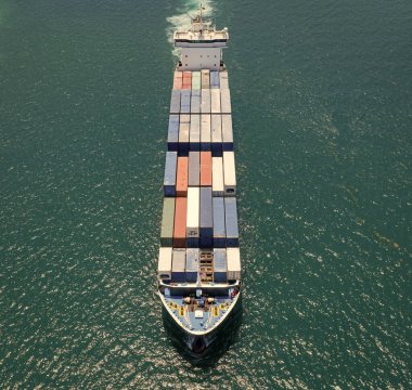 Ticari nakliye. Kargo gemisi denizde, hava manzaralı. Yük konteynırı kargo gemisine yüklendi. Konteynırlı bir hava kargo gemisi. Kargo işi. Konteyner gemisi. Nakliye lojistiği. Denize açılmak.