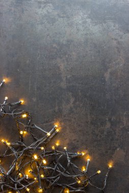 Sol alt köşesinde ışıklar olan siyah bir Noel kartı.