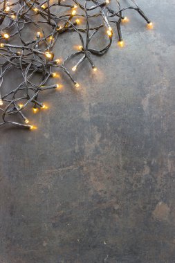 En üst köşede ışıklar olan siyah Noel kartı.