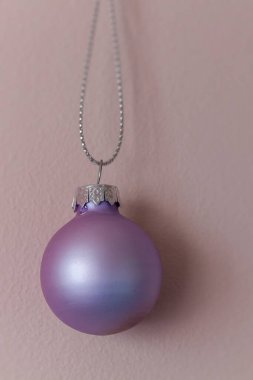 Pembe ve morla süslenmiş Noel süsünü kapat.