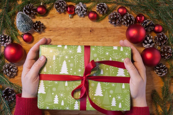 Feche Mãos Segurando Presente Natal Verde Com Fita Vermelha — Fotografia de Stock