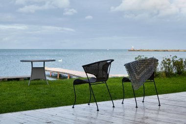 Unutulmuş bir şal, körfeze bakan boş bir kafede bir sandalyeye asılı duruyor.