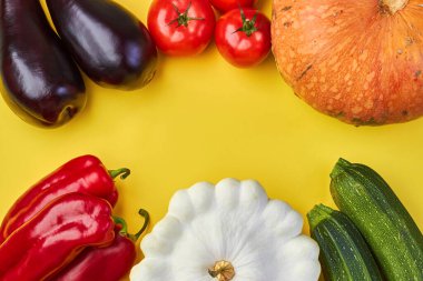 Sarı arka planda taze organik sebzeler.