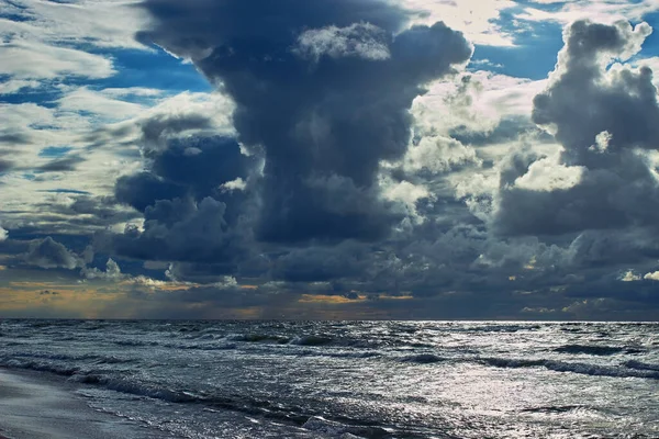 Nuvens dramáticas no céu acima das brilhantes ondas do mar — Fotografia de Stock