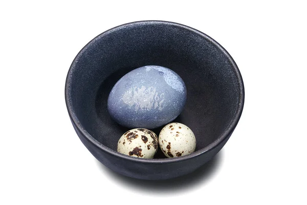 Перепел и куриные яйца в темной чаше — стоковое фото