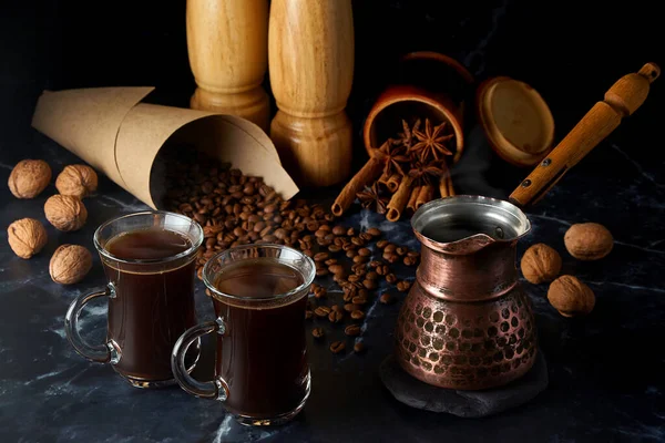 Türk ve arka planda baharatlı, fındıklı ve kahve çekirdekli iki fincan sıcak kahve.