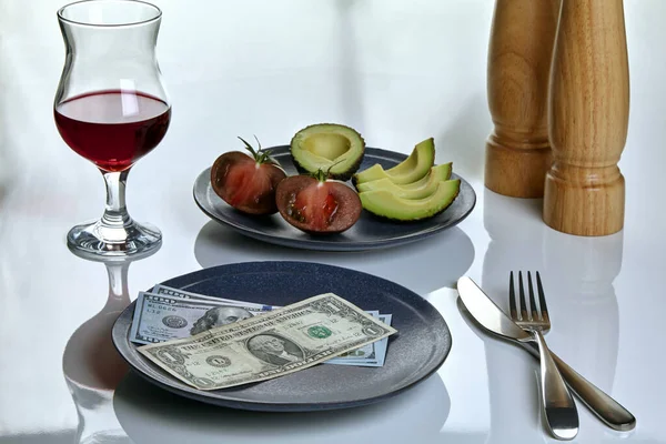 Plate with dollars and a plate of food on a white served table — Stock Photo, Image