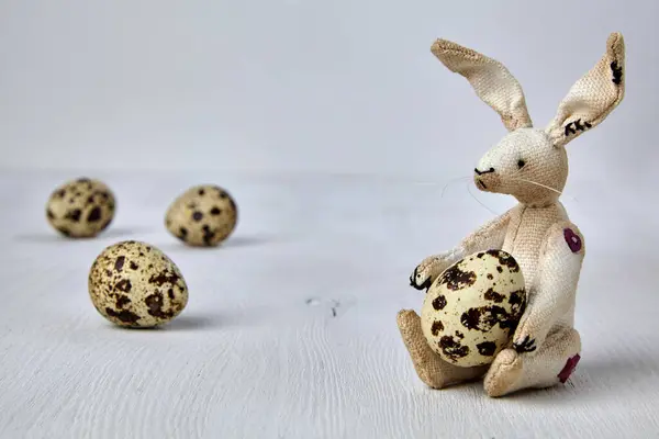 Yumuşak Oyuncak Tavşan Bıldırcın Beyaz Ahşap Arka Planda Benekli Yumurta — Stok fotoğraf