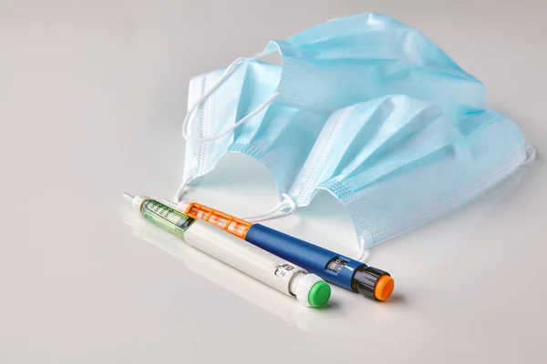 Bolígrafos Con Jeringa Insulina Máscaras Médicas Sobre Una Mesa Blanca —  Fotos de Stock