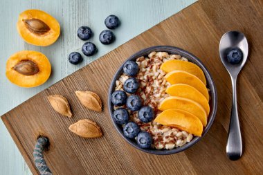 Keten tohumlu tam tahıllı yulaf ezmesi, yabanmersini ve kayısı dilimleri.