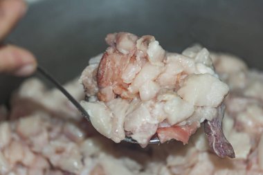 Bir kepçe içinde bir sürü doğranmış domuz yağı.