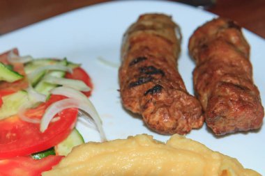 etli sosis, domates salatası ve bezelye püresi.