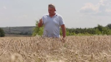 Çavdar tarlasında bir adam avucuna çivi saplıyor..