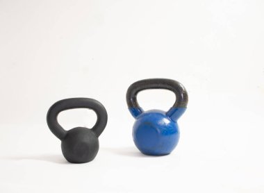 Farklı boyutlarda kettlebell, beyaz arka planda mavi ve siyah