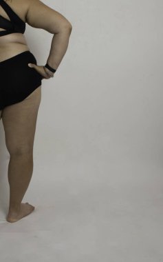 Tombul beyaz kadın beyaz arka planda pozitifliğe olan inancını ve sevgisini gösteriyor.