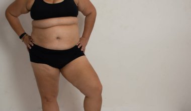 Tombul beyaz kadın beyaz arka planda pozitifliğe olan inancını ve sevgisini gösteriyor.