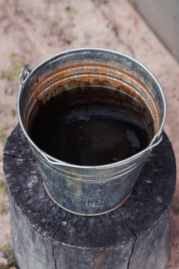 Terk edilmiş paslı metal su kovası..