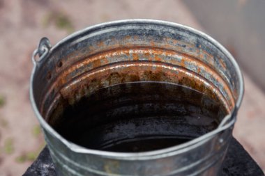 Terk edilmiş paslı metal su kovası..