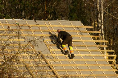 Erkekler güneşli zamanlarda çatıda çalışır.