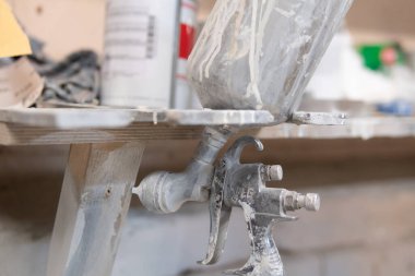 Boya kabininde kirli sprey tabanca. Kötü araba boyama.