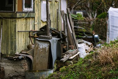 Eski ahşap tahtaları ve diğer şeyleri olan terk edilmiş küçük bir ev.