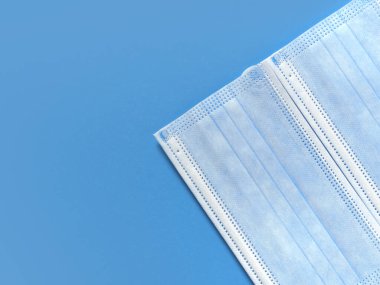 Tıbbi koruyucu maskeler mavi bir arka planda sınır oluşturur. Bireysel, tek kullanımlık cerrahi maske düz desen. Karantina sağlık hizmetleri, hijyen ve koronavirüs koruma kavramı