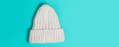 Sıcak yün örülmüş şapka turkuaz renkli arka plan. Şenlikli Noel giysisi.