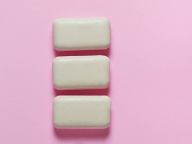 Tıbbi koruyucu maskeler ve pastel pembe arka planda lateks eldivenler. Bireysel, tek kullanımlık temizlik ekipmanları. Karantina sağlık, hijyen ve koronavirüs koruma kavramı
