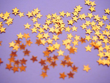 Lavanta kaplamasında altın yıldızlar parıldıyor. Şenlikli bayram, parlak zemin