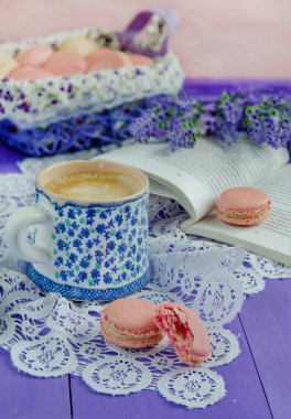 Bir kahve ahşap masa arka plan üzerinde renkli macaroons, lavanta çiçekleri ve 