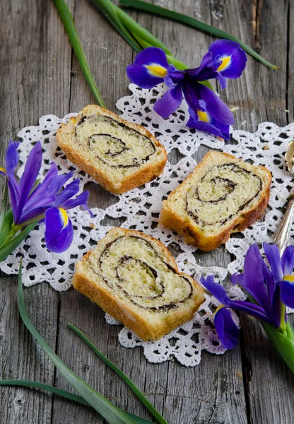 close-up view of yeast roll with cocoa and Iris flowers on the old wooden board