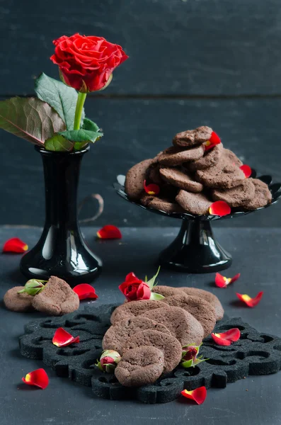 Çikolatalı Kurabiye Koyu Ahşap Bir Masa Bir Kırmızı Gül Yaprakları — Stok fotoğraf