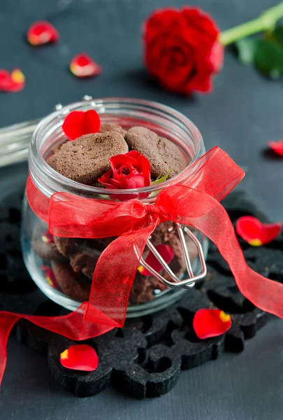 Çikolatalı Kurabiye Koyu Ahşap Bir Masa Bir Kırmızı Gül Yaprakları — Stok fotoğraf