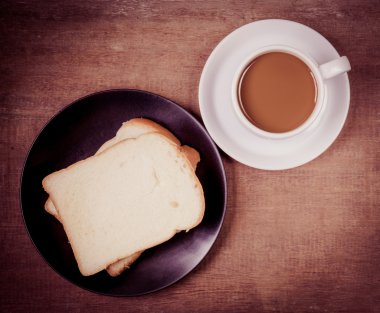 ahşap masa üzerinde kahve ekmek fincan