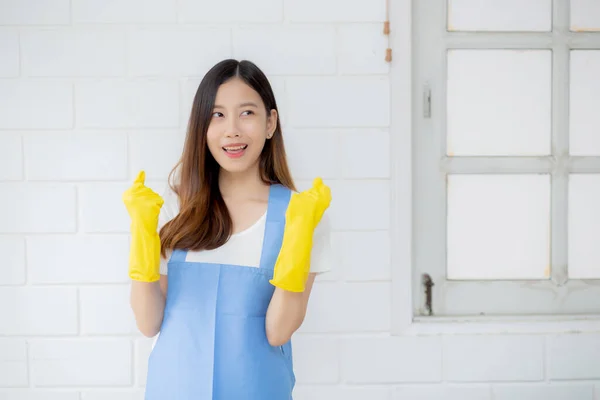 典型的年轻亚洲女人是穿着橡胶手套和围裙的管家 为家庭提供保护 穿女佣制服 清洁和洗涤 站着的女工是积极的 一个人 生活方式的概念 — 图库照片