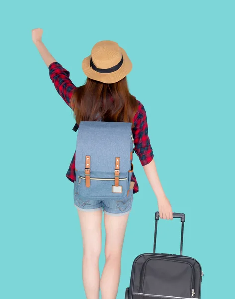 Back view beautiful young asian woman pulling suitcase isolated on blue background, asia girl having expression is cheerful holding luggage walking in vacation with excited, journey and travel concept.