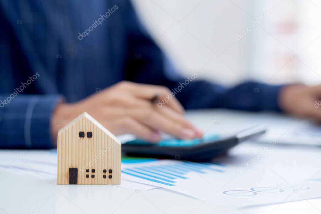 Hand of business man agent calculating loan of finance and investment for real estate, businessman and invest in property about home, construction or mortgage of home, male using calculator.