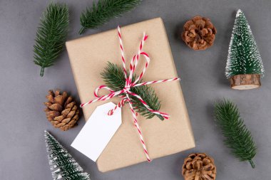 Hediye kutusunun içinde etiket dekorasyonu, yeni yıl ve xmas ya da yıl dönümü olan, çimento zemin arka planında etiketi olan bir Noel kompozisyonu, üst görünüm ya da düz alan, kopyalama alanı.