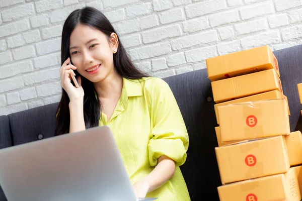 年轻的亚洲女人是企业家 与客户交谈 使用手提电脑 而在家里 物流和送货 网上购物时 女性是企业中小企业的销售者 — 图库照片