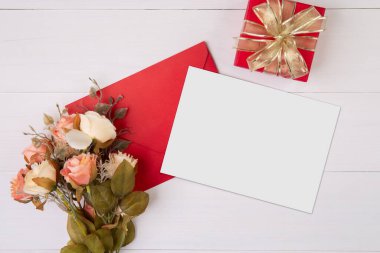 Sevgililer günü, tebrik kartı maketi, mektup ve çiçek ahşap masada, kartpostal boş ve hediye kutlaması masasında romantizm, yıldönümünde hediye ve kutlama, üst görünüm, tatil konsepti.