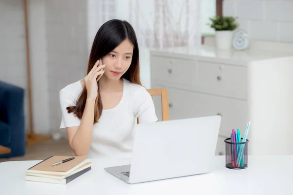 若いアジアの女性が電話をかけ ノートパソコンで自宅から仕事をし ノートパソコンを使ってインターネットに無料でアクセスし スマートフォン 国内生活 ビジネス コミュニケーションの概念について話す — ストック写真