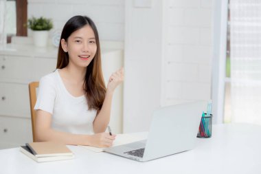 Genç Asyalı kadın dizüstü bilgisayarla çalışıyor ve planlama için fikir üretiyor, serbest mutlu kız heyecanlı ve not defterini düşünceli ve yazılı kullanarak başarı elde ediyor, iş kavramı..