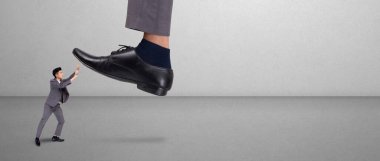 Otoritesi olan lider ya da patronun ayağı korkmuş çalışanı ezip geçiyor. Zorbalıkla dolu bir süit, güçlü bir iş adamı ve savunma, sömürü ve üstünlük, korkmuş ve mücadele, iş konsepti..