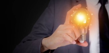 Elinde ampul, hayal gücü ve zeka, yenilik ve ilham, beyin sembolü ve çözüm ve bilgi, yaratıcı fikir ve başarı, iş ve pazarlama kavramı bulunan iş adamı.