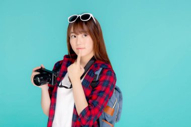 Güzel Asyalı genç bir kadın, yaz tatilini mavi arka planda izole etmeyi düşünüyor. Asyalı bir kız, elinde fotoğraf makinesi, tatilde turist yolculuğu gibi aktiviteler yapıyor..