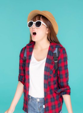 Güzel, genç Asyalı bir kadın yüksek sesle bağırarak tatilde bir şey anons etmek için mavi arka planda izole edilmiş heyecanlı bir seyahat yaz konseptinde turist kız seyahati..